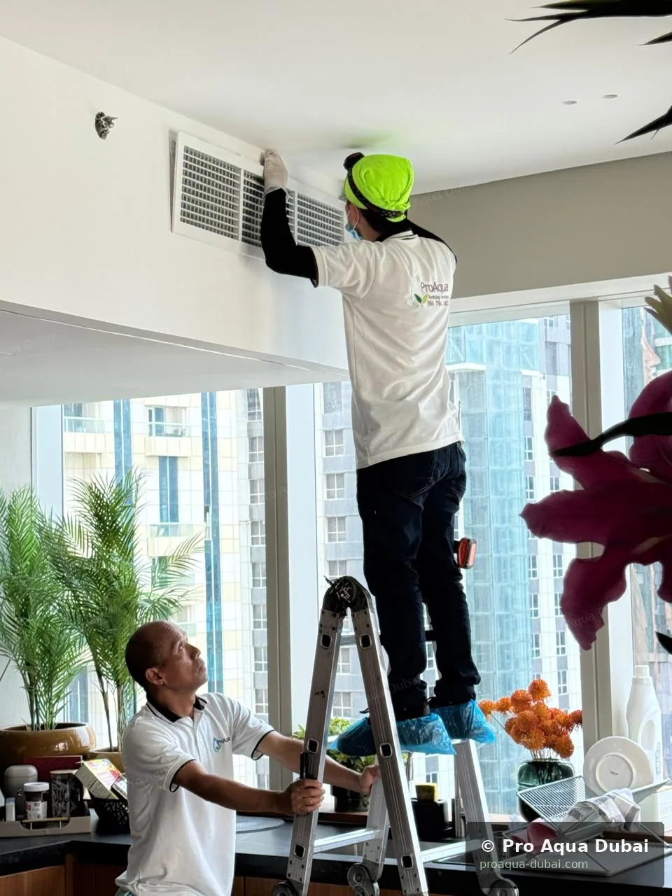 Pro Aqua crew working on AC duct grills — full-service cleaning Dubai 2025